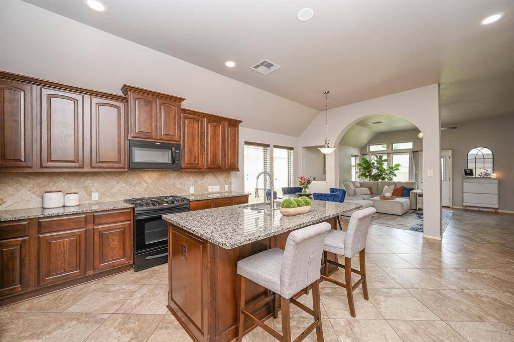The spacious kitchen is designed for both functionality and entertaining. With abundant cabinetry and generous counter space, preparing meals is effortless and enjoyable. There's plenty of room for friends to join and cook together, making hosting dinners a seamless and social experience.