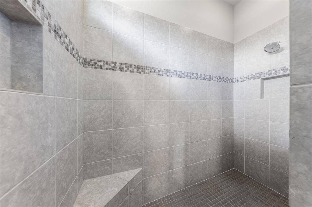 Take a step inside this custom enclosed shower with detailed tile accents. There's plenty of room for you to soak away your stress.