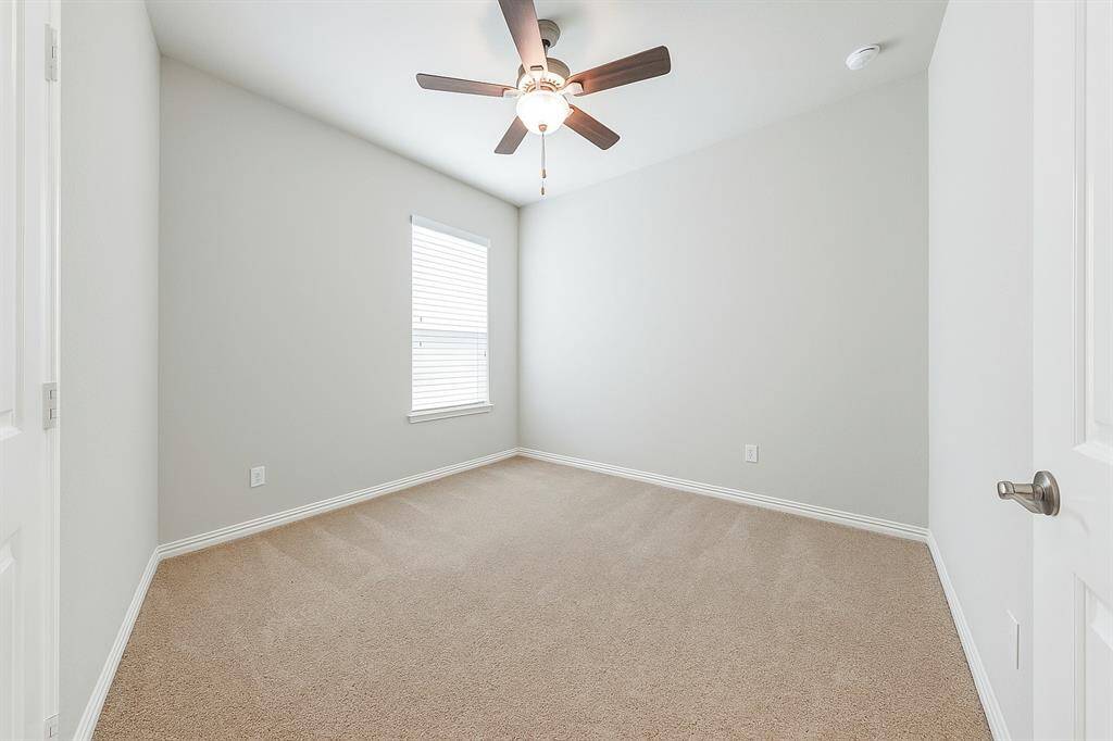 Comfortable secondary bedroom featuring a high ceiling, plush carpet for comfort and a window with blinds to bring in plenty of natural light creating a cheerful and welcoming space.