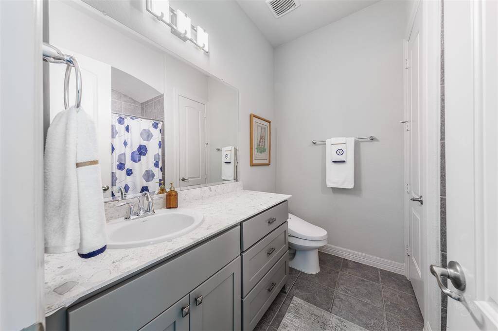 This secondary full bath provides a Quartz vanity
