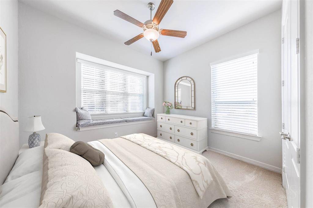 Comfortable secondary bedroom featuring a high ceiling, plush carpet for comfort and windows with blinds to bring in plenty of natural light creating a cheerful and welcoming space.