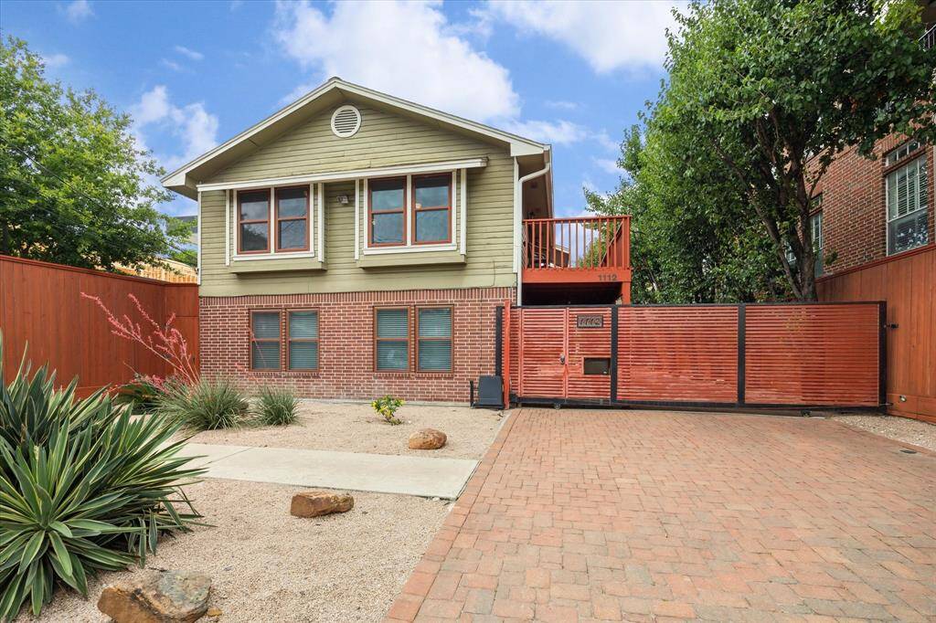 2 Charming two-story homes with a mix of brick and siding exterior. Features a gated entrance, paved driveway, and low-maintenance desert landscaping.
