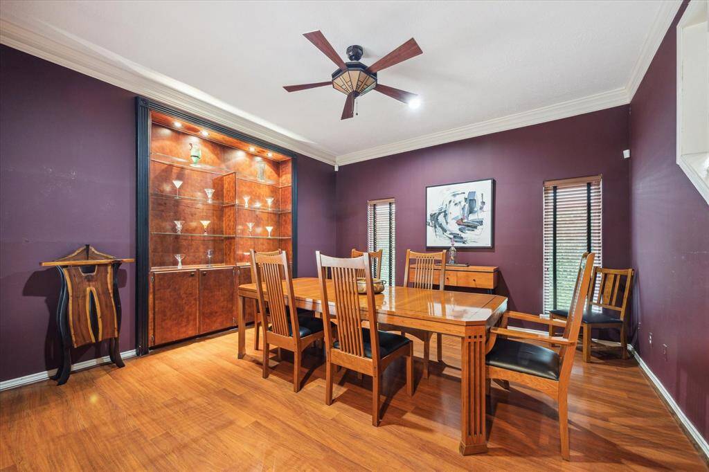 Rear House: Another view of this elegant dining room features rich purple walls, hardwood flooring. The display cabinet with lighting showcases glassware, adding a sophisticated touch.