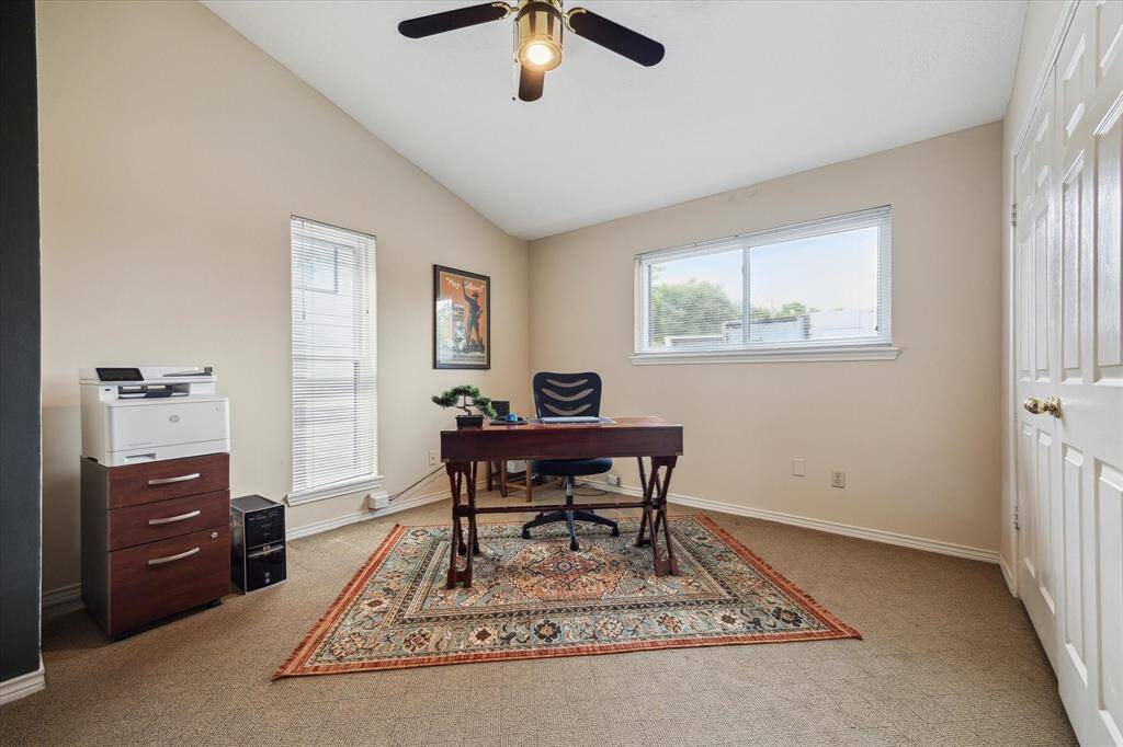 Rear House: A home office/reading nook at the upstairs landing featuring a large window for natural light, neutral walls, a ceiling fan, and ample space for a desk and storage.