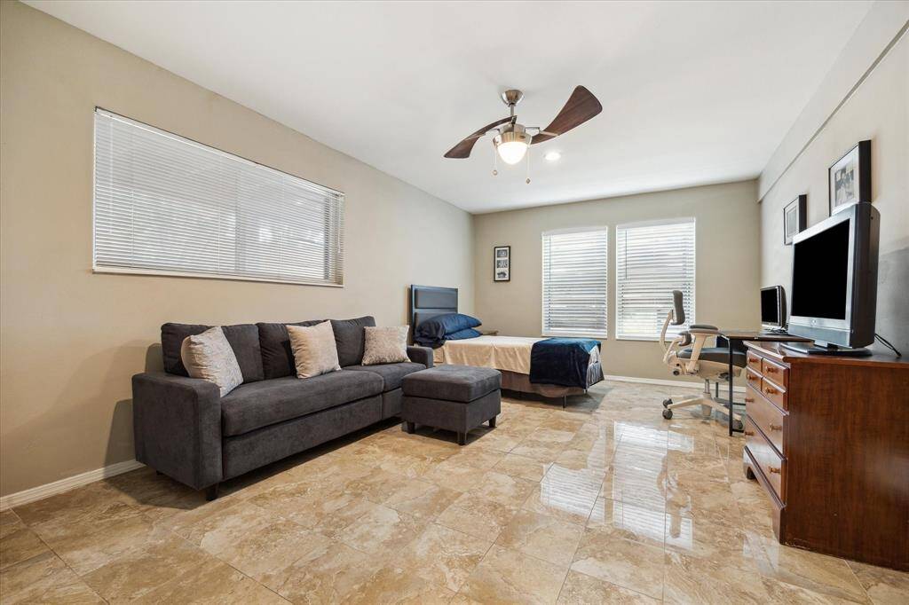 Front House: Second bedroom features beautiful flooring and neutral walls. The large windows and ceiling fan enhance the bright and airy atmosphere.