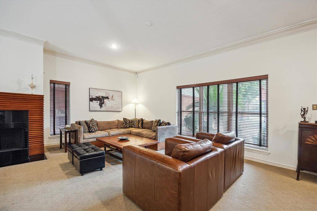 Rear House: Another view of the spacious living room with ample natural light, featuring a cozy fireplace. Large windows and neutral tones create a warm, inviting atmosphere.