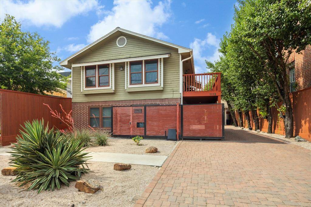 1112 Jackson Boulevard features a gated driveway and low-maintenance desert landscaping in the front yard. The property is lined with trees, offering some privacy.