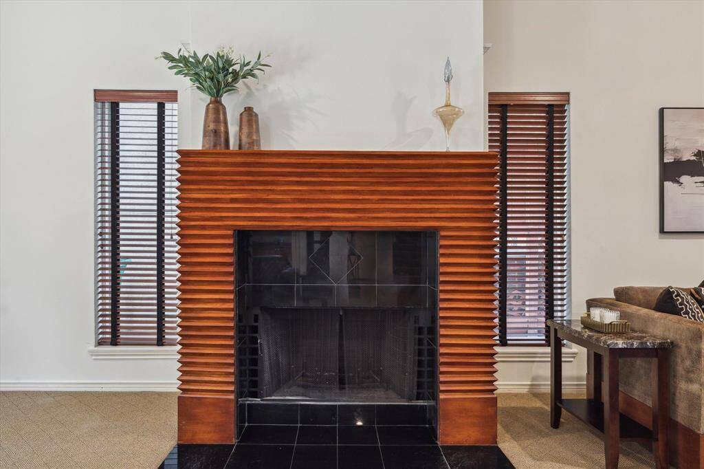 Rear House: Wood-accented fireplace flanked by tall windows with blinds in living room.