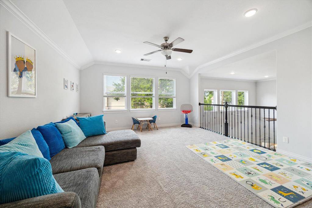 Located at the top of the stairs, this flexible game room offers plenty of space for play, lounging, or movie nights. Large windows draw in natural light, while the open railing provides a visual connection to the main living space below. Neutral tones and soft carpet make it a comfortable retreat for all ages.