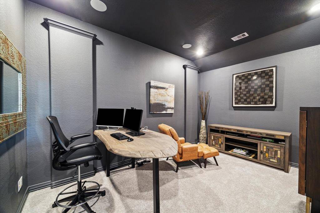 Tucked away for privacy, this media room/bonus space creates the perfect setting for a home theater, gaming den, or focused work zone. Recessed lighting, textured walls, and plush carpet add depth and warmth, while the layout allows for both productivity and relaxation.