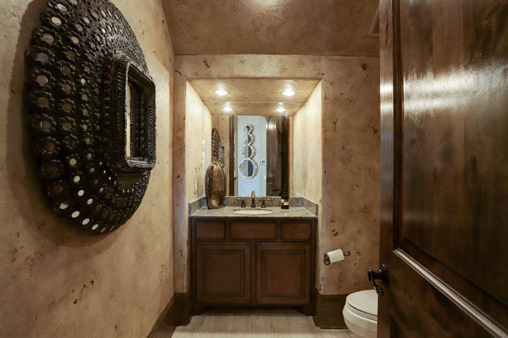 First floor powder bath with custom faux finished walls, stained cabinet and storage.
