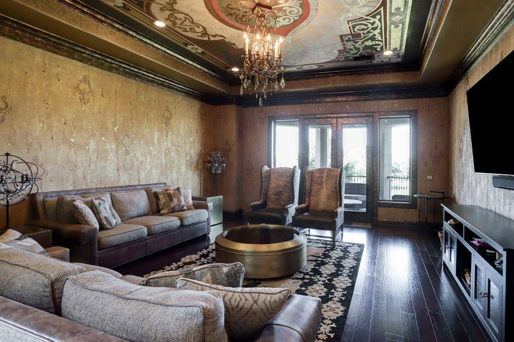 Second floor living room or game room with wood flooring, faux finished, hand painted decorative walls and hand painted mural on the ceiling. Enjoy the balcony overlooking the beautiful 15th fairway with lake view.