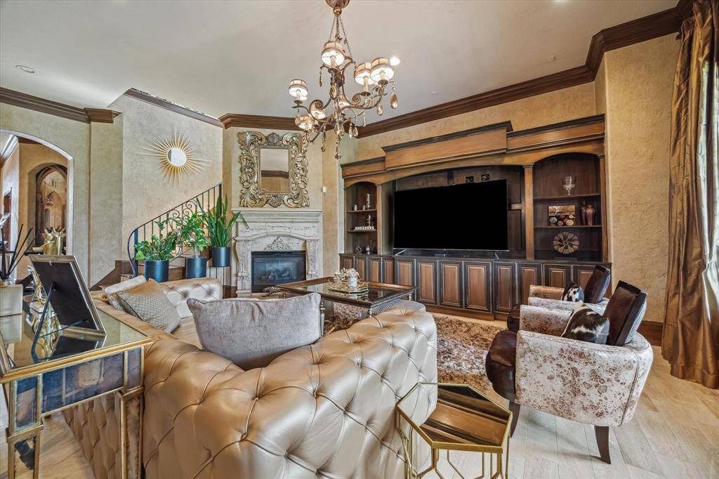 Family room with skip trowel finished walls, custom built ins, cast stone fireplace surround, chandelier and ceiling to floor drapery panels.