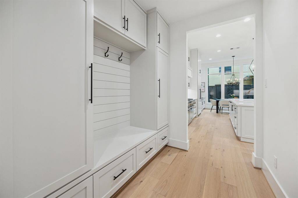 As you enter the home from the Garage, you will find a conveniently located Mud Room with Built-In Cabinet, Hooks For Coats and Backpacks, Plus a Bench with Storage Drawers.