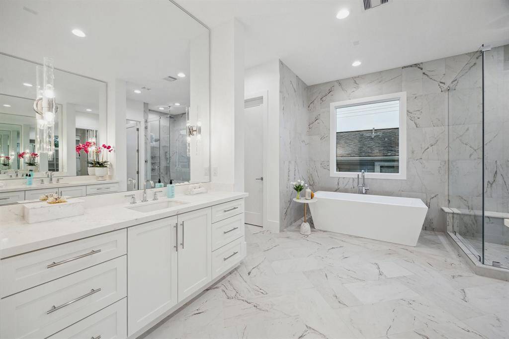 Primary Bath with Dual Counters, Shaker Style Cabinets and Drawers, (Soft Close Drawers and European Blum Hinges on Cabinet Doors) Slab Quartz Counters with Dual Under-Mount Sinks, Mirrors with Pendent Lighting and 12 x 24 Tile Floor with a Matt Finish in a 45 Degree Herringbone Pattern.