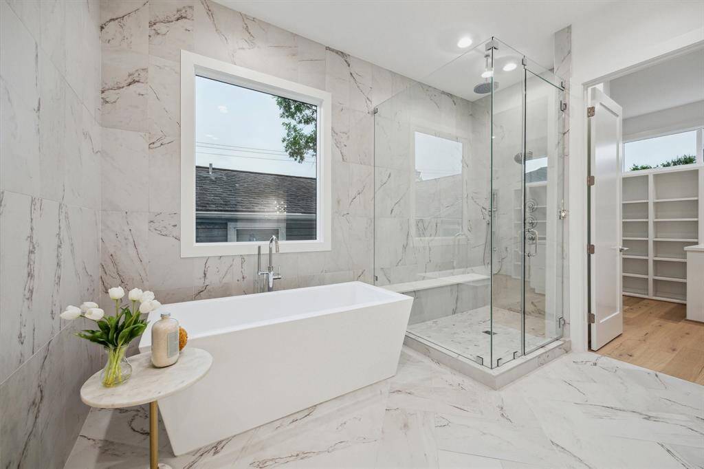 Free-Standing Soaking Tub with Floor Mounted Tub Filler, 12 x 24 Tile Surround on the Wall. Gorgeous! Large Walk-In Shower with Frameless Shower Door, Built-In Seat, Rain Can Shower Head, Wall Mounted Shower Head and a Hand Held Shower. There is also a separate commode area.