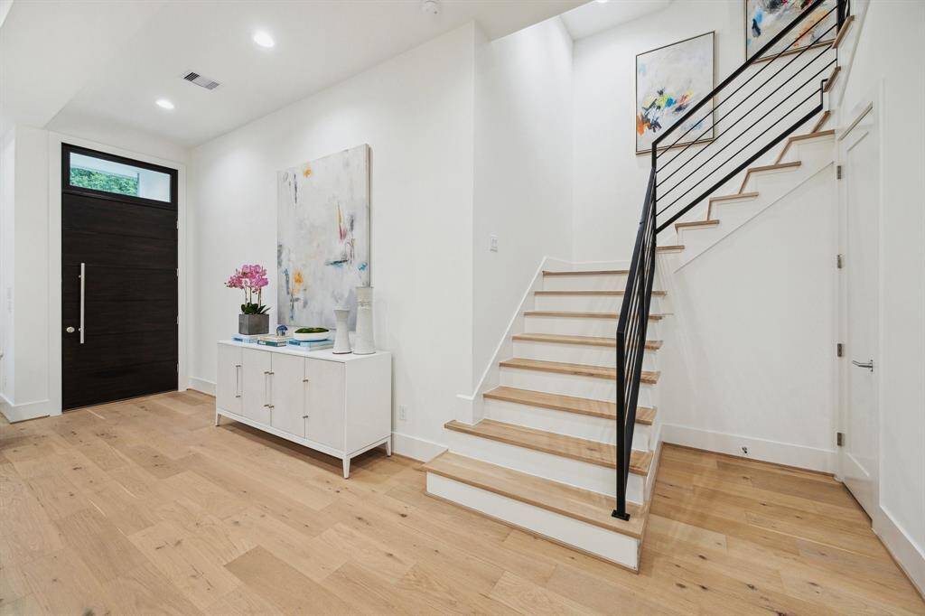 Entrance of the home with a stunning wrought iron staircase.