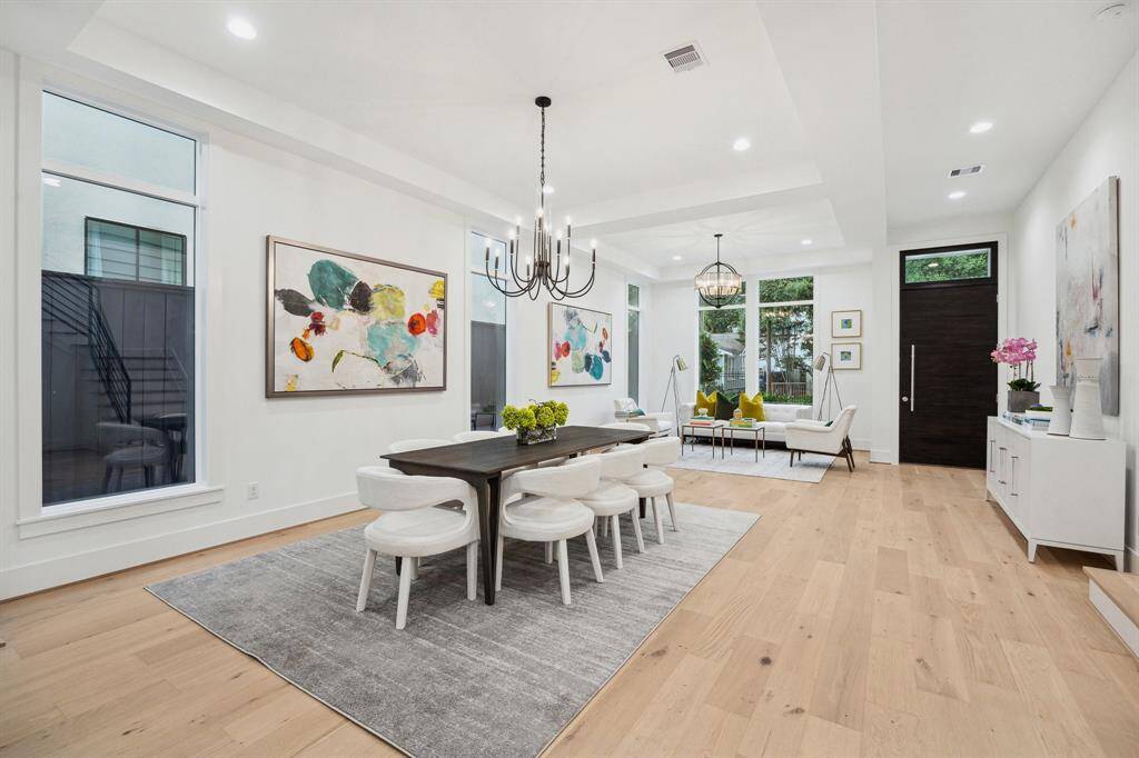 Entrance with Formal Living Room that is open to the Formal Dining Room. There is a Chandelier finished in Textured Black in the Dining Room.