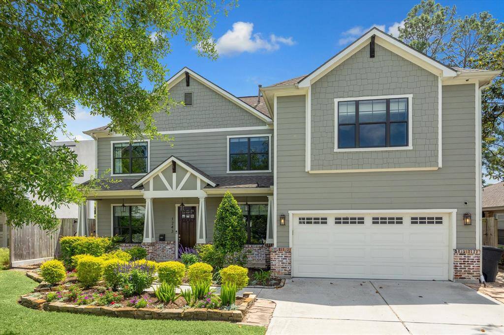 Beautifully maintained garden with lush greenery and colorful flowers. The attached garage and spacious driveway complete the exterior.