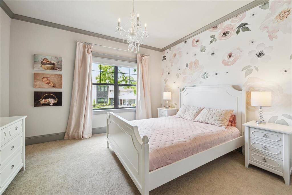Large secondary bedroom boasts large window overlooking front yard, and adorable chandelier. Crown molding throughout