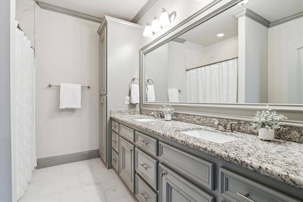 Secondary bathroom with double sinks and shower/tub combo
