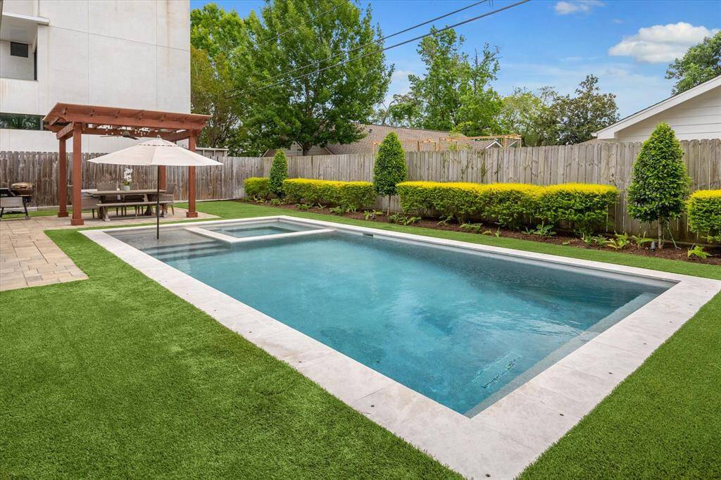 Great size pool features tanning shelf, hot tub and a custom pool safety net for use with younger kids