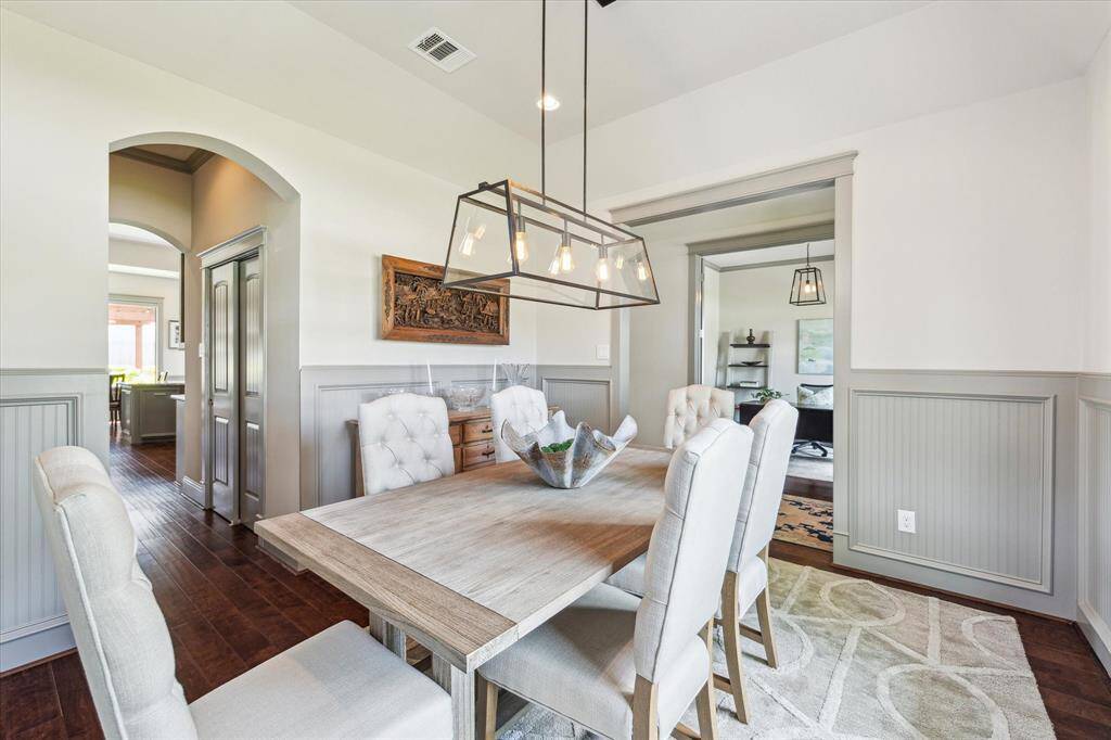 Dining room with wainscot border and arched entrance to bar and pantry area
