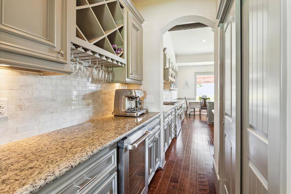 Coffee/Wine bar with beverage fridge, undercabinet lighting and built in wine storage. Pantry behind sliding doors