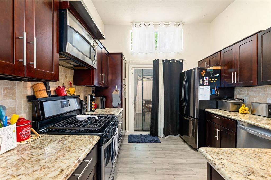 Featuring granite countertops and ample wood cabinets.