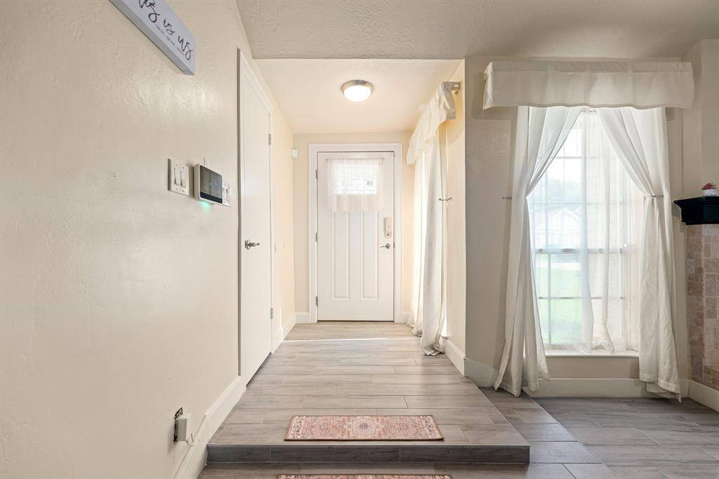 Bright entryway with tile floors, natural light, and smart home features.