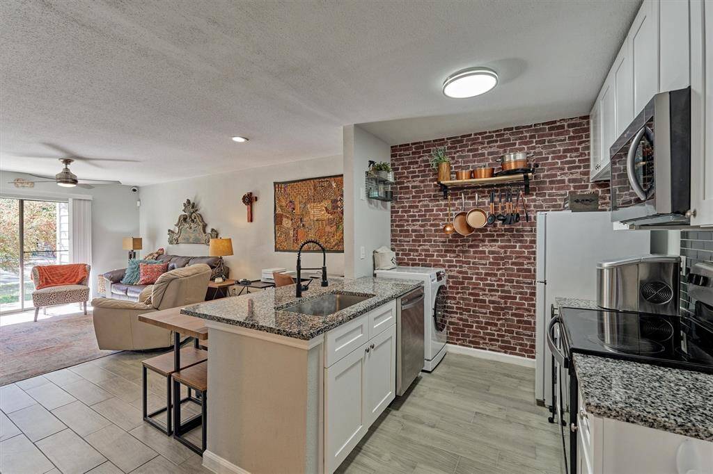 Experience culinary elegance in this radiant kitchen, boasting sleek granite countertops and classic shaker-style cabinets.