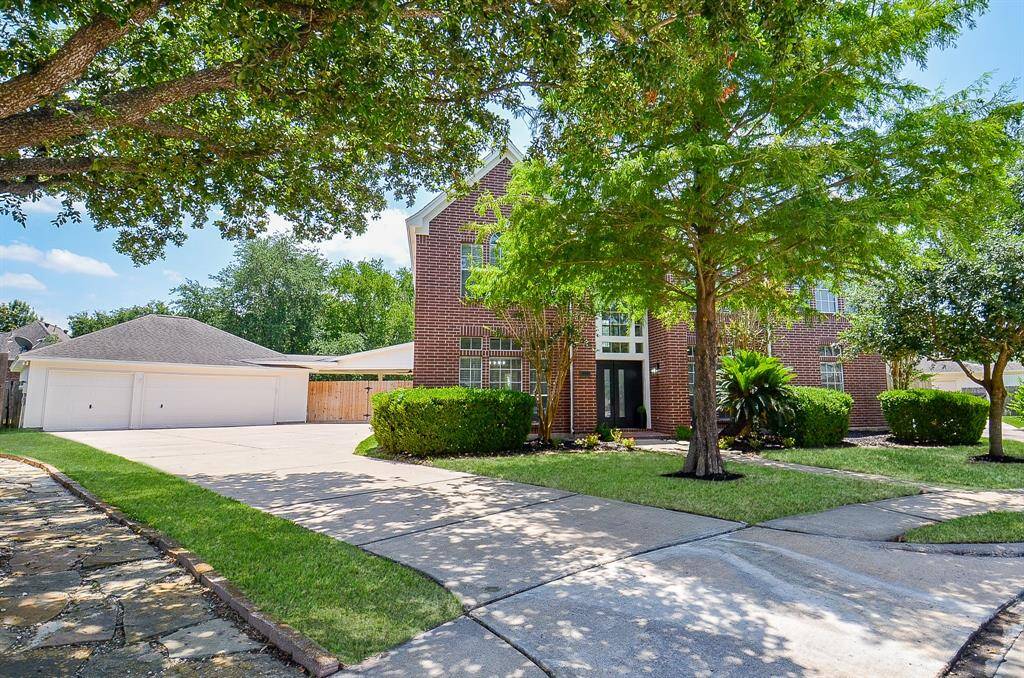 This is a spectacular spacious two-story brick home with a three-car garage. The well-maintained front yard features lush green grass and mature trees, providing excellent curb appeal