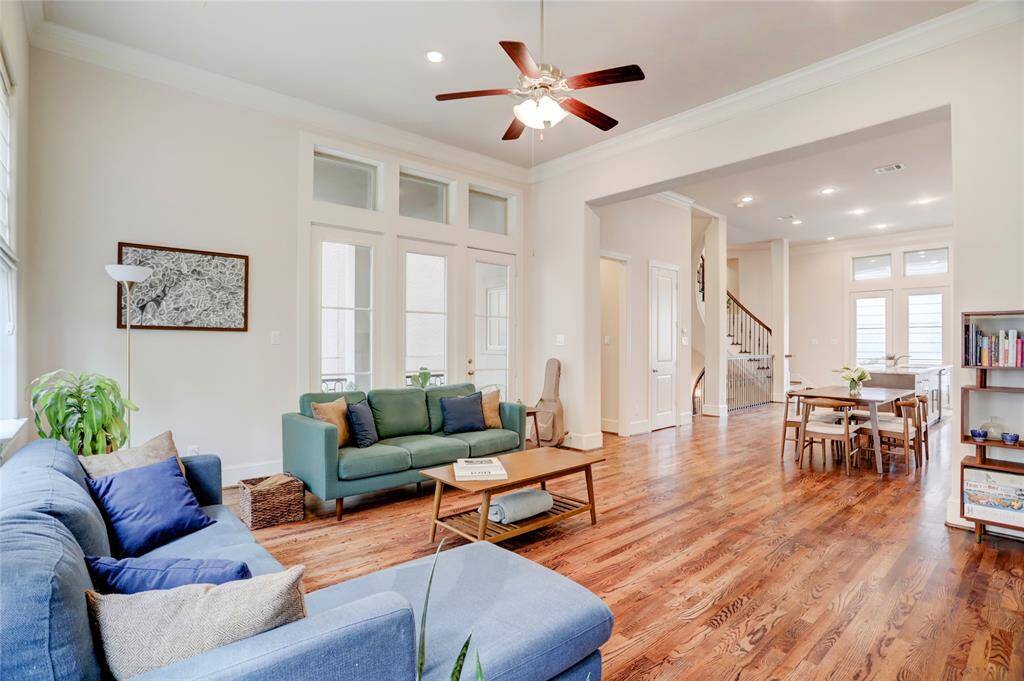 Large living room with open floor plan that flows so well into the dining area and kitchen. Notice the glass door to the side balcony.  You will love the high transom windows up above. Powder 1/2 bathroom located down small hallway next to the living area.