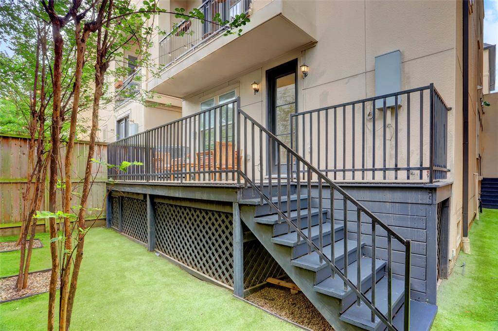 Wood privacy fence! Back yard and side yard with artificial turf for easy maintenance. Notice the upper balcony.