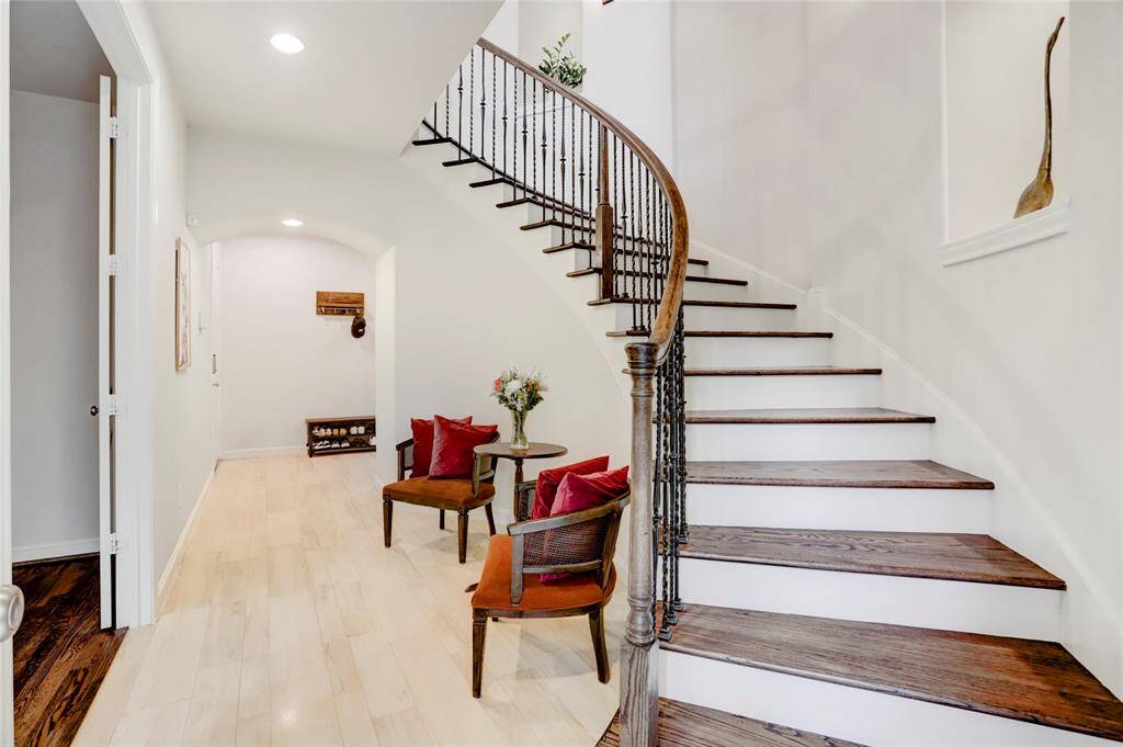 View of down stairs foyer on the 1st level.  Door on the side near curved archway leads to the attached 2 car garage. Gleaming durable floors. Recessed lights. Double door leads to downstairs guest bedroom with ensuite full bathroom.