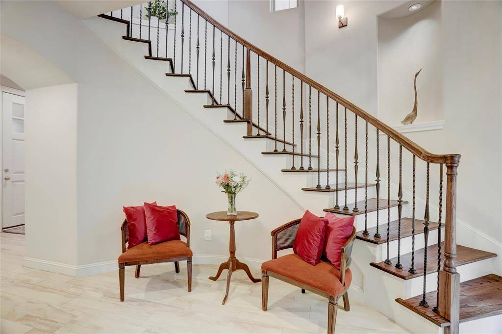 Sophisticated curved staircase with wrought iron spindles and real hardwood stairs! Notice the pretty illuminated curved arch niches that ascend up the staircase! Perfect spot to highlight your special pieces for display.