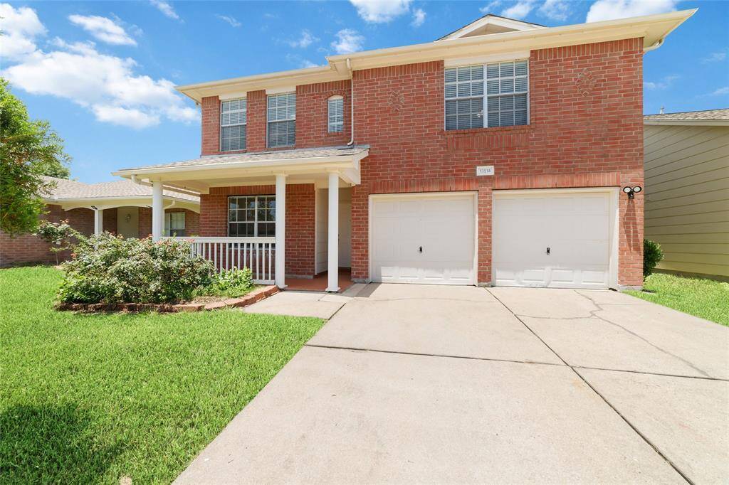 This two-story brick home features a welcoming front porch.