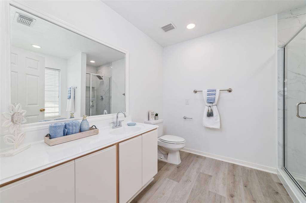 This modern bathroom features a spacious layout with a large mirror.