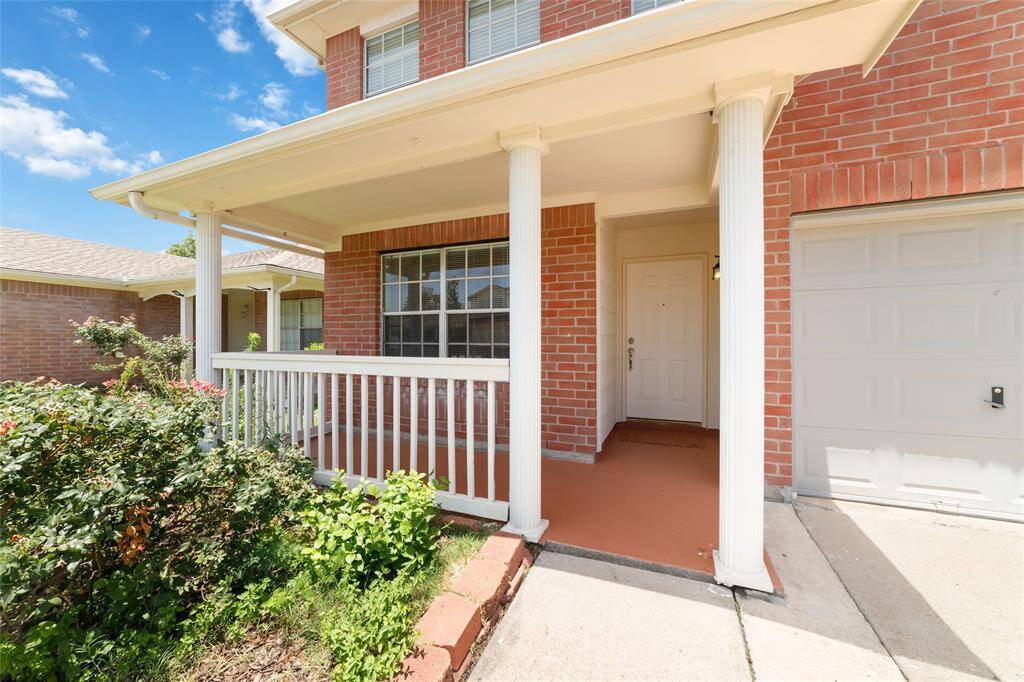 This photo shows a covered porch featuring classic white columns.