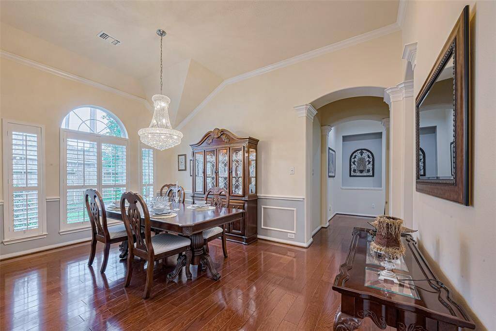 Another view of the stunning chandelier. An arched hallway and art niche create a graceful transition to the family room.