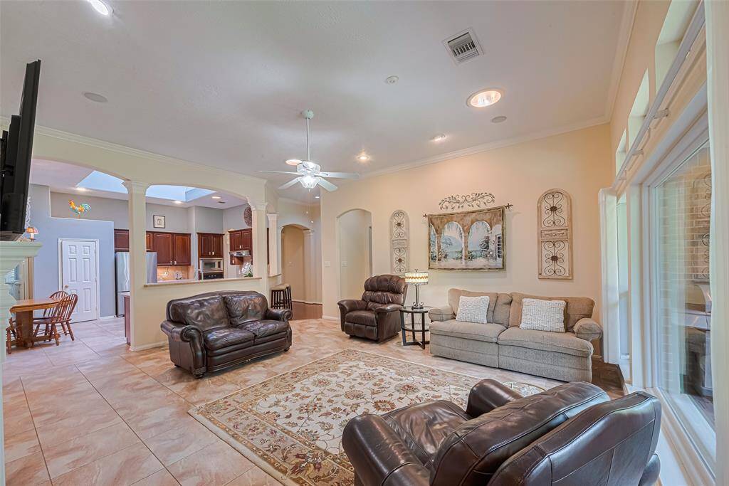 Two solar tubes and a large picture window brighten the living room. The open layout is perfect for entertaining, with bar top seating for four around the kitchen. Arches, columns, crown molding and transom windows carry through this space.