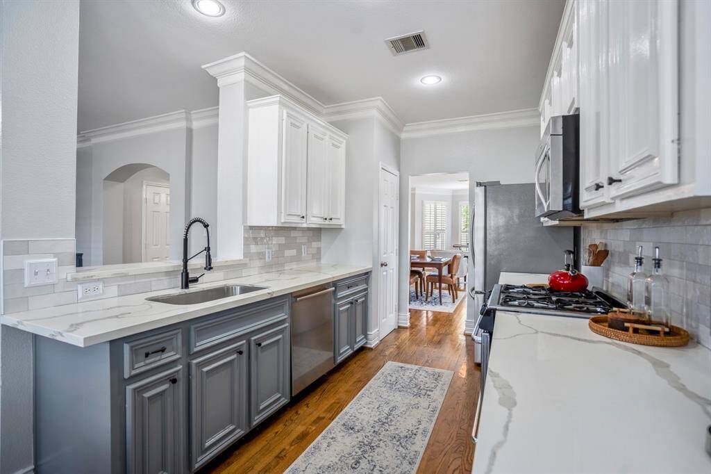 This bright and thoughtfully updated kitchen features stainless steel appliances, sleek quartz counters, and timeless finishes that make everyday cooking feel like a treat.