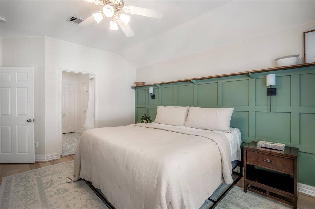 A second look at the impeccably designed primary bedroom reveals just how spacious and functional it is, with enough room for a sitting area, vanity desk and dresser.