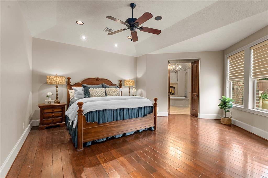 The dramatic master suite is privately located downstairs and boasts hardwood flooring, reader task lighting, built-in speakers, recessed lighting, custom shades and ceiling fan.