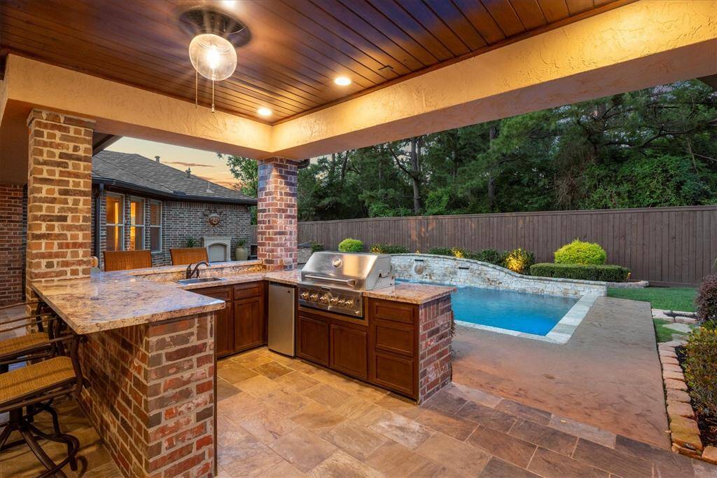 The outdoor kitchen is complete with granite counters, stainless Jenn-Air grill bar and built-in refrigerator