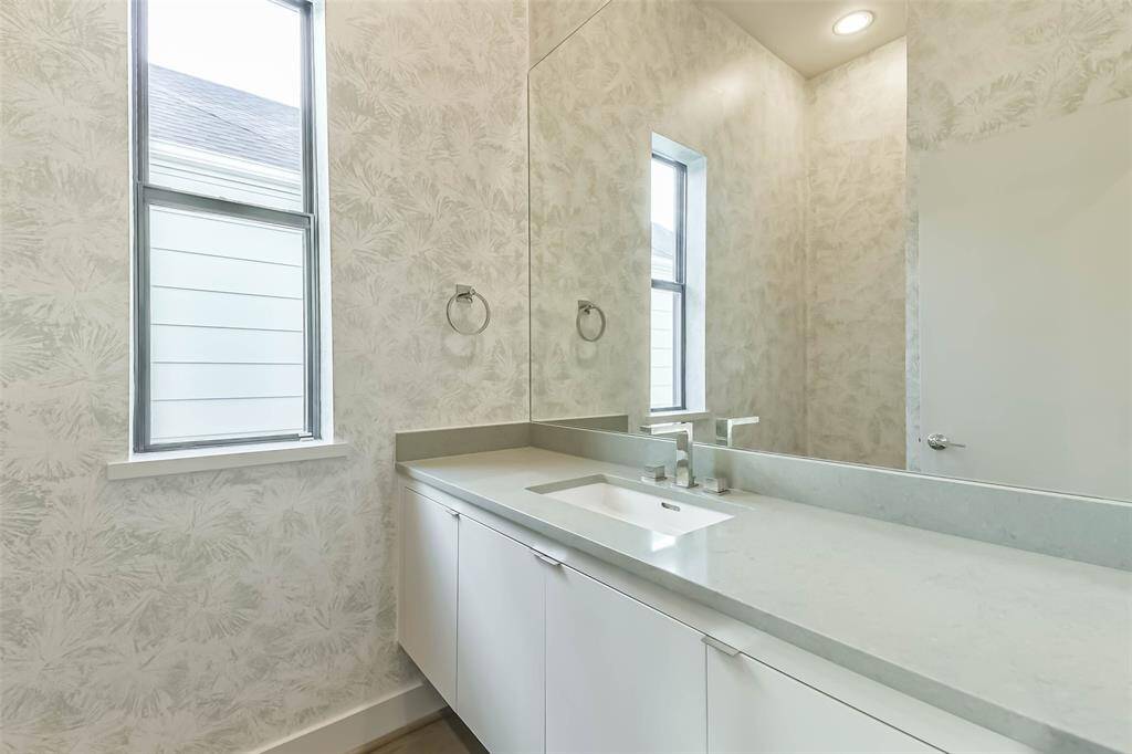 Powder bathroom conveniently located on second floor between living room and dining room.  Features include silestone countertops,  storage and designer wallpaper.