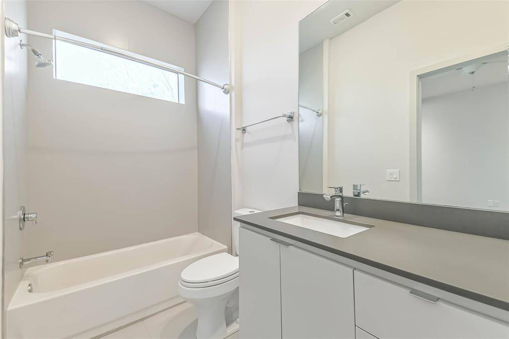 The secondary bathroom is enhanced by windows that allow natural light to permeate the space. Abundant storage with custom cabinets and walk-in closet add to the exceptional features of this home.
