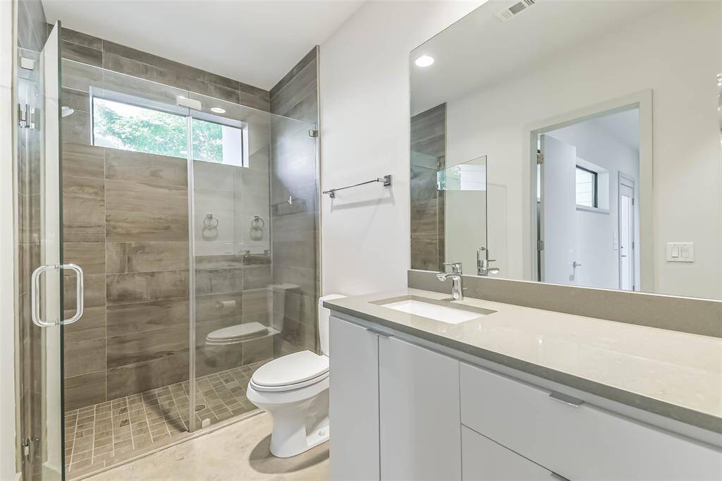 The first floor bathroom is pristine with oversized shower,  quartz countertops and tile shower and flooring.  Abundant storage, counter space and large closet complete this space.