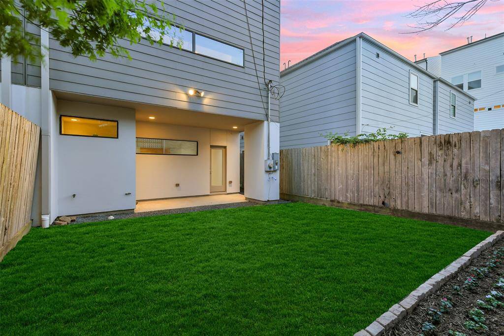 The private backyard is spacious and features freshly landscaped grass and beds!  Note the covered patio with recessed lighting with plenty of room for lounging.