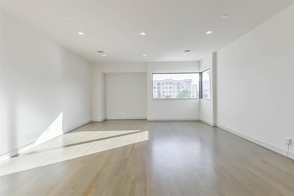 Family room showcases large picture windows that look towards Hermann Park and Texas Medical Center.  Natural light highlights the white oak floors. There is ample room for multiple seating areas.